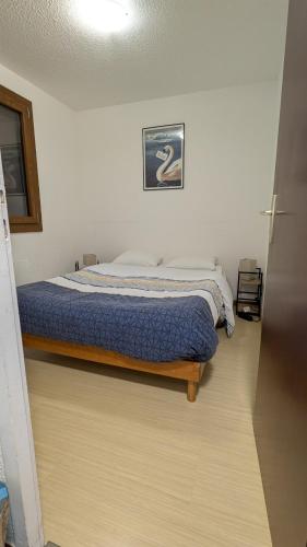 a bedroom with a bed with a blue comforter at Le Panoramic Evian in Évian-les-Bains