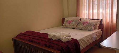 a bedroom with a bed with two towels on it at Godiva Homestay in Cochin