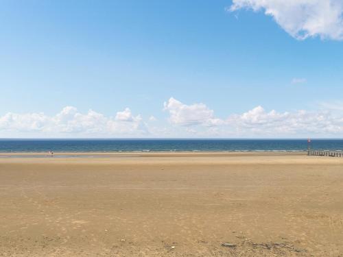 an empty beach with a pier in the distance at Long John Cottage in Redcar