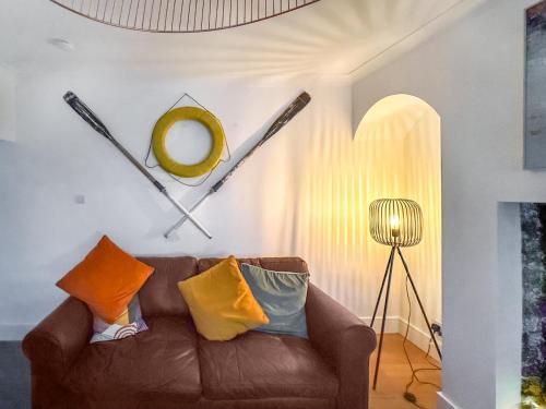 a living room with a brown couch and a mirror at Long John Cottage in Redcar