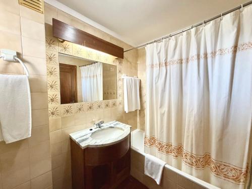 a bathroom with a sink and a shower curtain at Algardia Marina Parque by Garvetur in Vilamoura