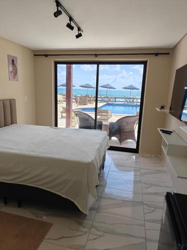 a bedroom with a bed and a view of the ocean at Pousada Porto Meu Amor in Porto De Galinhas