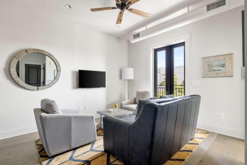 a living room with chairs and a table and a mirror at Fire Tower Classy 1BR in Downtown Charleston in Charleston