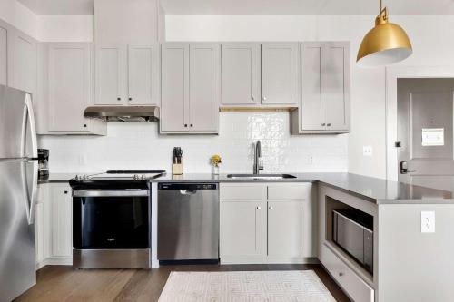 a kitchen with white cabinets and stainless steel appliances at Fire Tower Classy 1BR in Downtown Charleston in Charleston