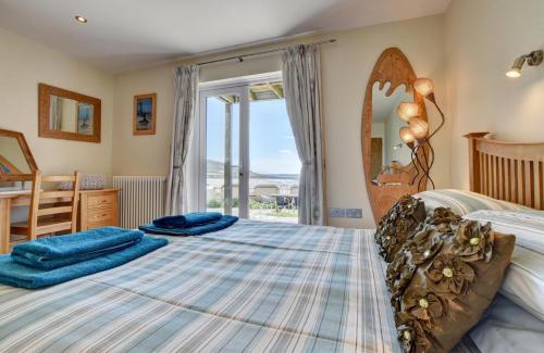 a bedroom with a large bed with a large window at 3 Bed in Croyde oc-spind in Croyde