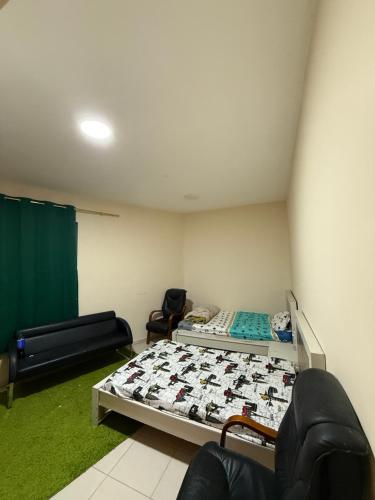 Camera con letto, divano e sedia di Cozy Room Rashdiya 1 Ajman ad Ajman