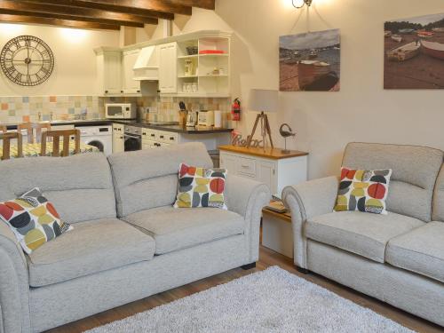 un soggiorno con due divani e una cucina di Rook a Broadhempston