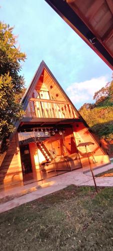 a large wooden house with its door open at Chalé Bela Vista in Munhoz