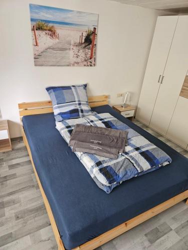 a bed in a bedroom with a blue mattress and a picture at Ferienwohnung Gabi in Eigeltingen