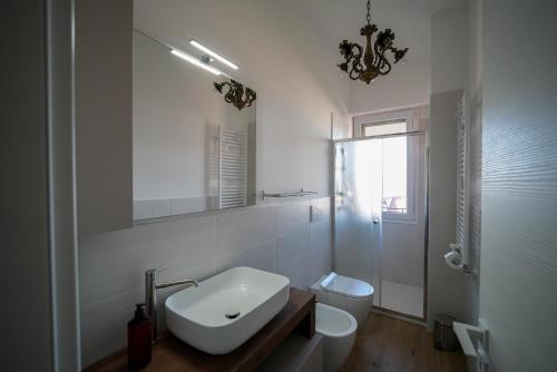 a white bathroom with a sink and a toilet at Appartamento con vista città - SmartCheck-In & Wifi Fibra in Campobasso