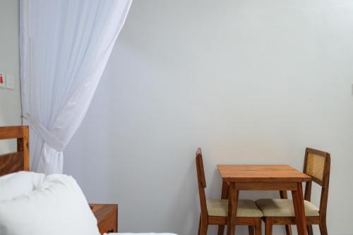 een slaapkamer met een tafel en stoelen en een bed bij Extreme Adventure Park in Busika