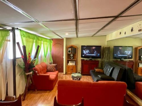 a living room with red furniture and a flat screen tv at Depa 1 habitación equipado coyoacan in Mexico City