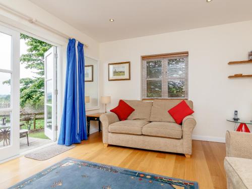 ein Wohnzimmer mit einer Couch und einem Fenster in der Unterkunft The Bothy in Mathon