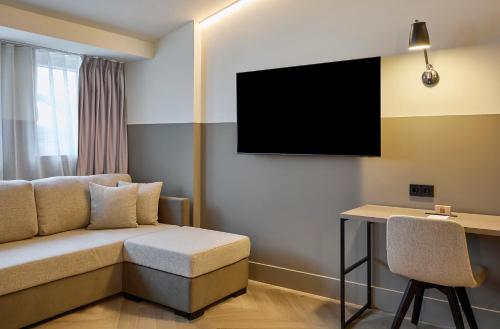 een hotelkamer met een bank en een bureau bij Casa Serras Andorra in Andorra la Vella