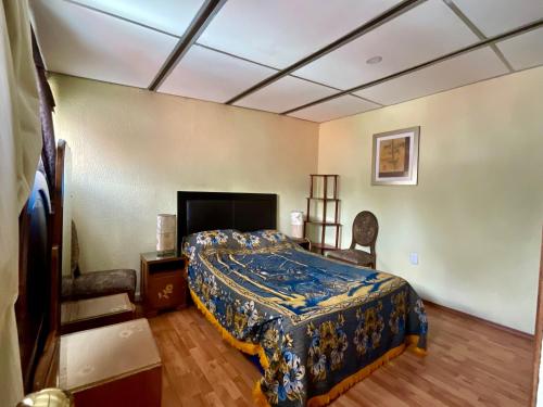 a bedroom with a bed with a blue comforter at Depa 1 habitación equipado coyoacan in Mexico City