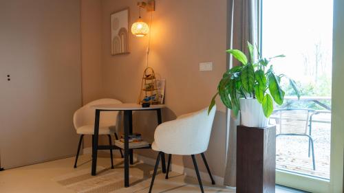 una stanza con tavolo, sedie e una pianta di Mera Luxe Wellness B&B, Adults Only, Ibiza-Bohemian Style Suites, Prive Outdoor Wellness, Massage, Vuurkorf, Gratis Wijn-Bubbels a America