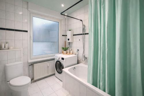 een badkamer met toilet, bad en wastafel bij Green Plants 24 7 Check In 4 Persons in Kelkheim