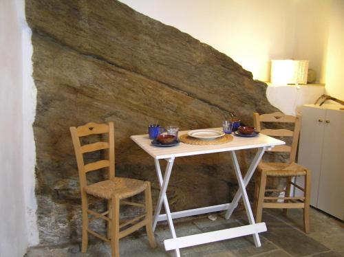 een tafel en stoelen voor een muur bij Liotrivi, traditional house in Apollonia