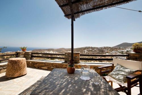 een tafel met een parasol op het balkon bij Liotrivi, traditional house in Apollonia