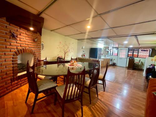 a dining room with a table and chairs and a brick wall at Depa 1 habitación equipado coyoacan in Mexico City