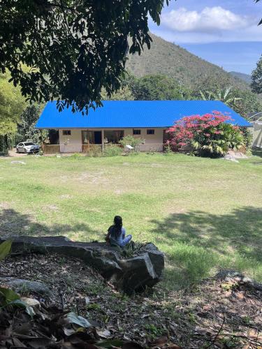 a person sitting on a rock in front of a building at Suelo Vivo Eco Hotel in Bochalema
