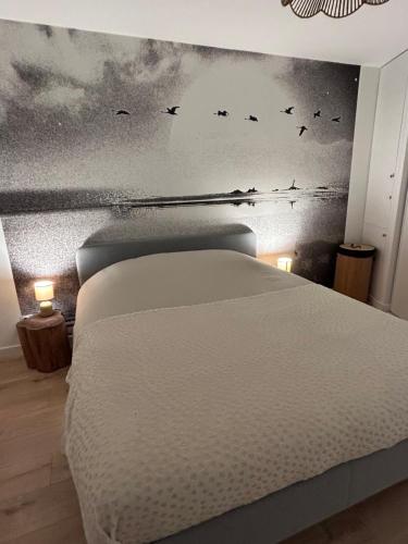 - une chambre avec un lit avec des oiseaux sur le mur dans l'établissement Proximité du port de Perros Guirec, à Perros-Guirec