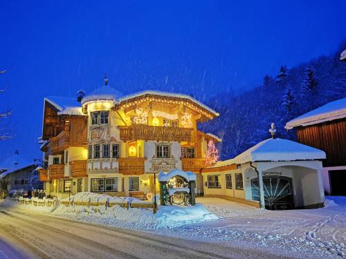 a large building in the snow at night at Ferienschlössl Harmonie in Holzgau