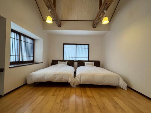 a bedroom with two beds and two windows at Fuji-Kurohime- in Shinano