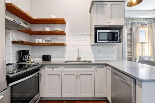 a kitchen with white cabinets and a sink at King Street Condo - Endless Outdoor Space in Charleston