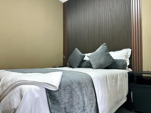 a bedroom with a large bed with blue and white pillows at Zengu in Lusaka
