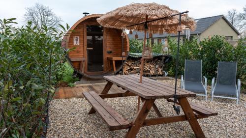 un tavolo da picnic in legno con ombrellone e sedie di Mera Luxe Wellness B&B, Adults Only, Ibiza-Bohemian Style Suites, Prive Outdoor Wellness, Massage, Vuurkorf, Gratis Wijn-Bubbels a America