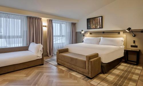 a hotel room with a bed and a chair at Casa Serras Andorra in Andorra la Vella