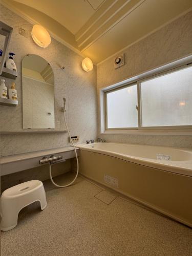 een badkamer met een bad, een wastafel en een spiegel bij Fuji-Kurohime- in Shinano