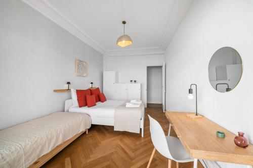 a bedroom with a bed and a table and a desk at Le COQ Livieri - AC- WiFi - Seafront - town centre in Menton