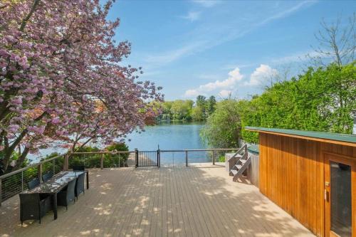 een houten wandelpad met bankjes en een meer bij Cherry Blossom Lake House in Lake Peekskill
