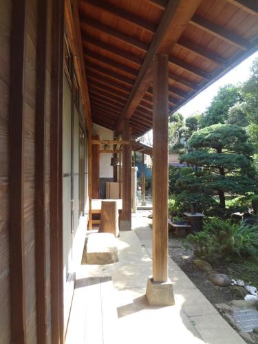 a porch of a house with a wooden roof at Mokkoan in Tokyo