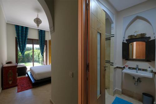 a hallway to a bedroom with a bed and a mirror at AG Hotel & Spa Marrakech in Marrakech