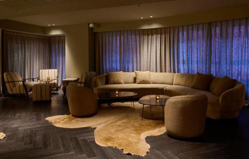 a living room with a couch and tables and curtains at Casa Serras Andorra in Andorra la Vella
