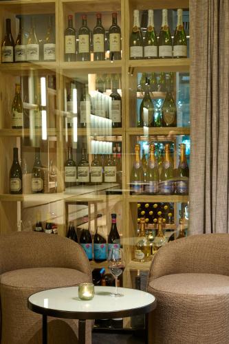 a room with two chairs and a table and wine bottles at Casa Serras Andorra in Andorra la Vella