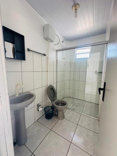 a bathroom with a shower and a toilet and a sink at Pousada Emanuel in Araranguá