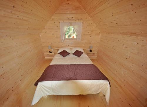 a bedroom with a bed in a wooden room at Glamping Organic Farm Slibar in Tržič