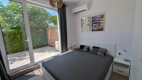 a bedroom with a bed and a large window at Brisa Apartment in Burgas City