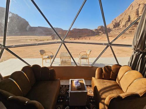 een kamer met twee banken en uitzicht op de woestijn bij Wadi Rum Luxury Camp in Wadi Rum