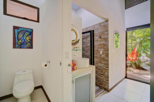 bagno bianco con servizi igienici e finestra di Villa Wolaba a Puerto Viejo