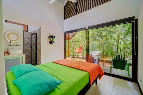 una camera con un letto verde e una grande finestra di Villa Wolaba a Puerto Viejo