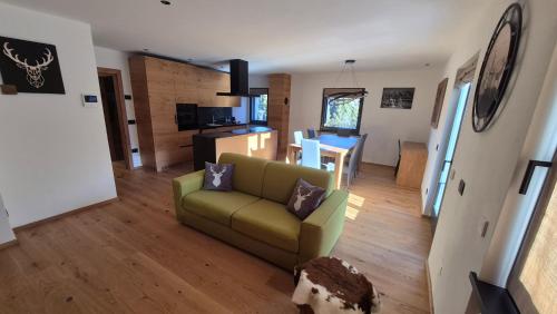een woonkamer met een bank en een keuken bij La Trementina Apartment & Spa in Dimaro