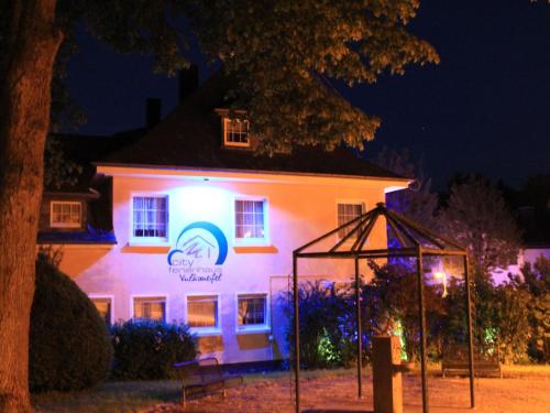a white building with a sign on it at night at Apartment Daun by Interhome in Daun
