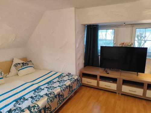 a bedroom with a bed and a flat screen tv at Apartment Daun by Interhome in Daun