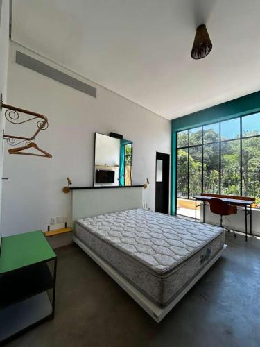 a bedroom with a large bed and a large window at Castelo dos Tucanos Host in Rio de Janeiro