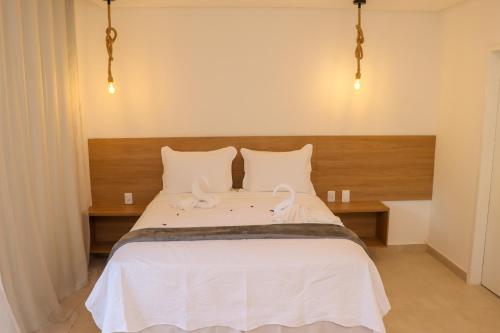 a bedroom with a bed with two white swans on it at Hotel Maragogi Beach Club in Maragogi